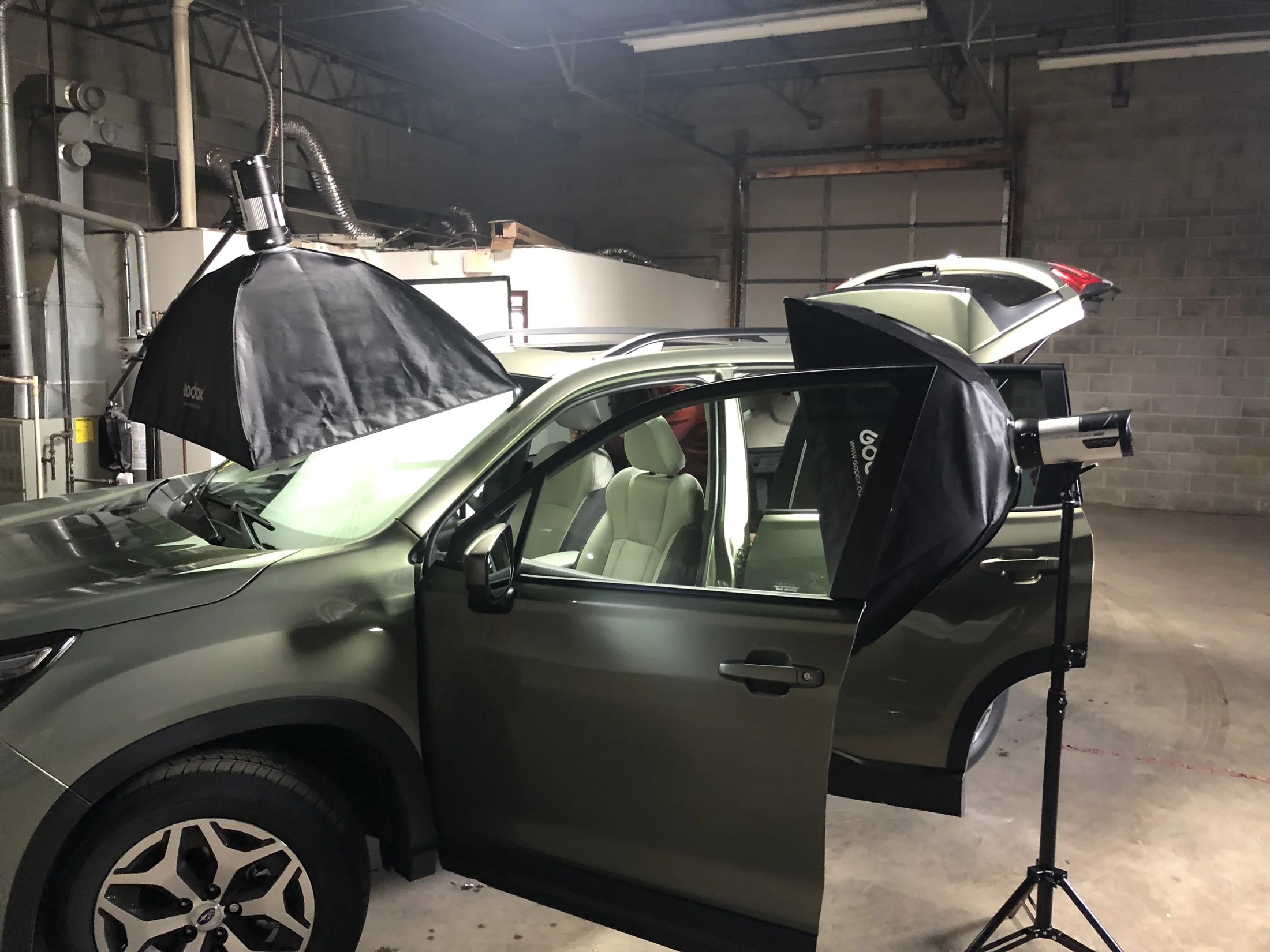 Vehicle in a garage surrounded by softboxes during a photography setup